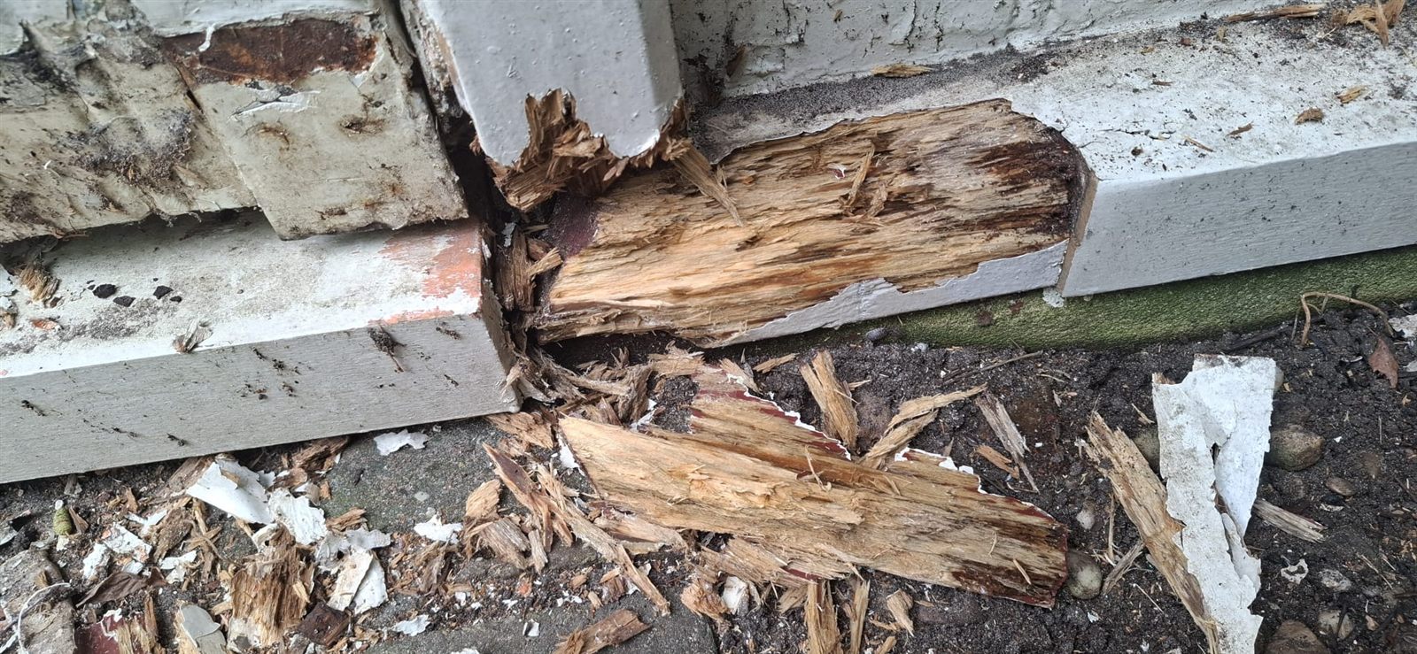 Zacht, verrot hout dat bij de hoek van de deur uit het kozijn breekt